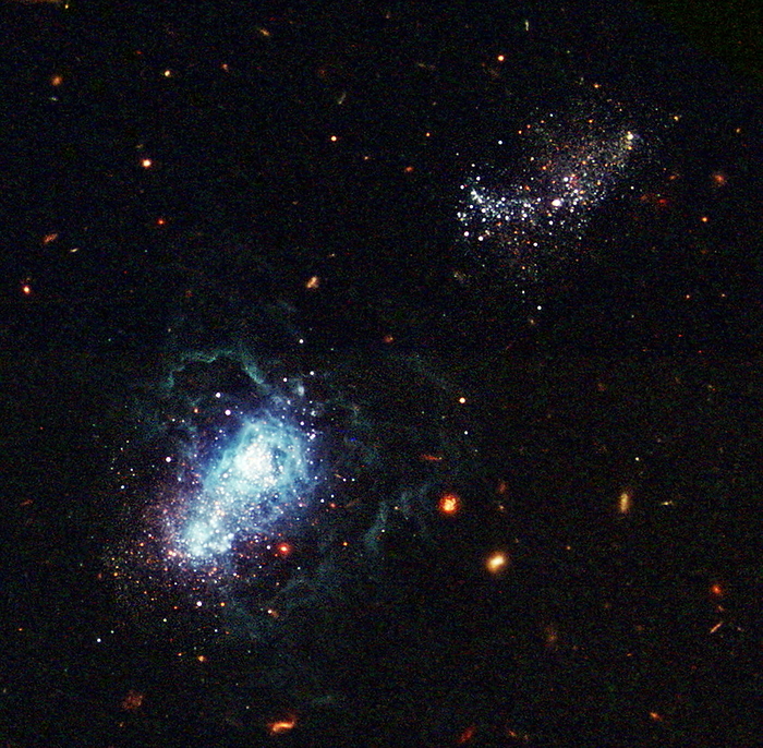 Youngest galaxy I Zwicky 18 Youngest galaxy I Zwicky 18. Hubble Space Telescope image of the galaxy I Zwicky 18  lower left , the youngest galaxy known at the time the image was taken. The galaxy might be as young at 500 million years old, which means that it didn t begin star formation until over 13 billion years after the Big Bang. The bright white regions in the centre of the galaxy are starbirth regions. This burst of star formation is thought to have been triggered by gravitational interactions with the nearby galaxy at upper right. I Zwicky 18 is around 45 million light years from Earth. This image was taken by the Advanced Camera for Surveys on the HST in 2003.