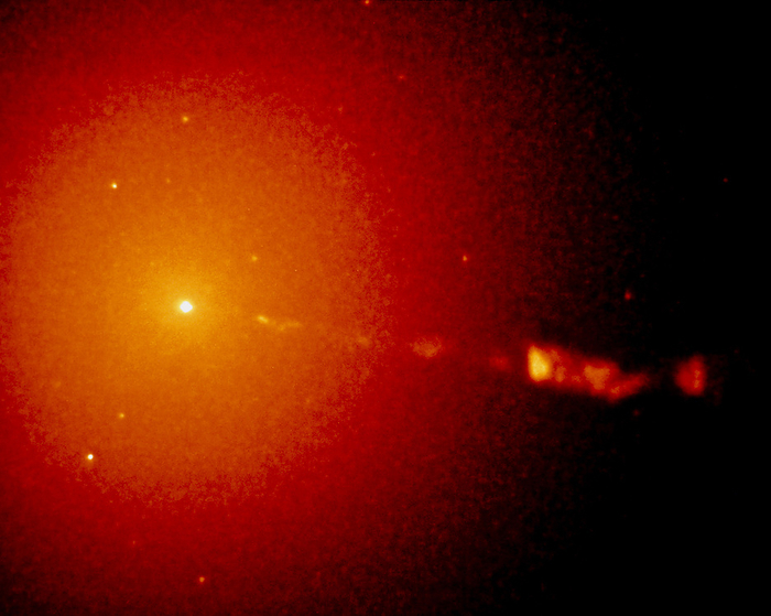 Core of galaxy M87 seen by Hubble Space Telescope The core of the elliptical galaxy M87  NGC 4486  seen from the Wide Field Planetary Camera onboard the Hubble Space Telescope  HST . HST enabled the discovery of a stellar cusp in the core of M87 seen here as the brightest white spot. In this region the density of stars is 300 times greater than a normal elliptical galaxy. Current models suggest that a black hole of 2.6 billion solar masses lies in the stellar cusp of M87   pulls all the stars in this region towards the centre. The black hole is powering the jet of plasma which departs from the nucleus   extends outwards for 4000 light years. North is at top right.