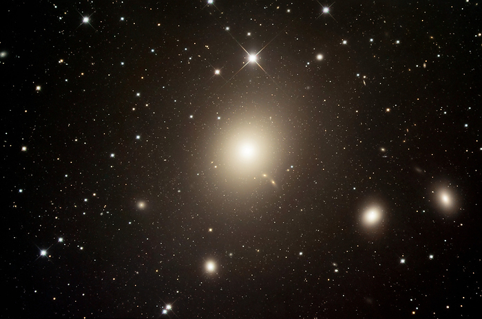 Virgo A galaxy  M87  Virgo A galaxy  M87 , optical image. This elliptical galaxy is located approximately 52 million light years from Earth in the constellation Virgo. It is one of the largest and brightest known galaxies, containing several trillion stars  our own galaxy, the Milky Way, contains no more than 400 billion. The galaxy is unusual for the large numbers of globular star clusters associated with it. These are visible here as faint dots around the galaxy. The large fuzzy blobs are other galaxies in M87 s local group.