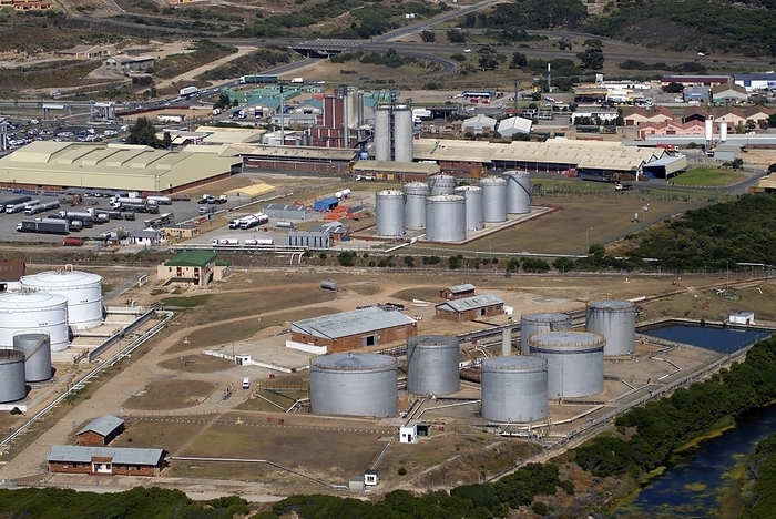 Mossel Bay oil refinery, South Africa Mossel Bay oil refinery. Aerial photograph of an oil refinery s storage tanks, industrial structures and chimney stacks. An oil refinery is where oil is refined from the crude state  in which it is pumped from the ground  into the separate components used as fuels, and as raw materials for the petrochemical industry. Photographed at Mossel Bay, South Africa.