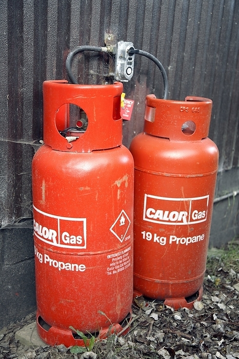 Liquefied propane gas cylinders Liquefied propane gas cylinders outside a house. Propane is used as a fuel for heating and cooking.