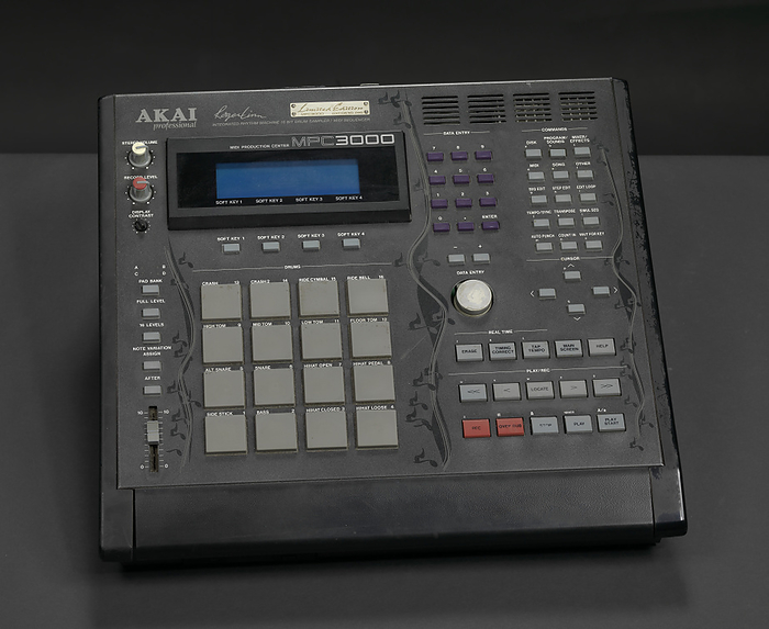 MIDI Production Center 3000 Limited Edition used by J Dilla, 2000. Creator: Akai Professional. An AKAI MPC 3000 Limited Edition integrated rhythm machine, drum sampler, and midi sequencer used by record producer and artist J Dilla. The machine consists of a black plastic box with a small screen in the upper left corner, multiple key pads, and a vertical design of black musical notes along the left, center and right of the box. Grey type at the top of the machine reads,  AKAI professional Roger Linn INTEGRATED RHYTHM MACHINE 16 BIT DRUM SAMPLER MIDI SEQUENCER . Gold plaque above the type reads,  Limited Edition MPC3000 EDITION NO. 0449 .