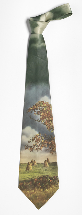 Necktie worn by Ira Tucker Sr., ca. 1950. Creator: Metcalf Neckwear Company. Ira B. Tucker  1925 2008  was the lead singer with the American gospel group The Dixie Hummingbirds. Tucker was with the band for 70 years, from 1938, when he joined at the age of 13, until his death. The tie is made of a silk like material with a   x201c photo image  x201d  landscape of haystacks during sunset. A tree with orange and red leaves in autumn is present above the hay stacks, and dark clouds are found towards the top of the tie. A circular logo in the silk like material on the verso bottom has the text   x201c INDIAN SUMMER   COLOR PHOTO  x201d  in white. The tie has been lined with a silky white material and a thicker woven white material. Black ink handwriting on the interior of one of the folds on the verso reads   x201c TUCKER  x201d .