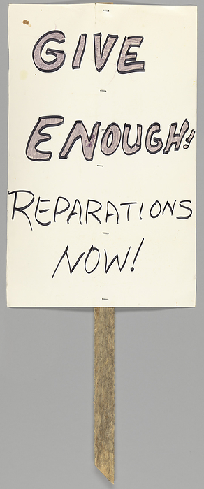 Placard calling for reparations for the Tulsa Race Massacre, ca. 2001. Creator: Unknown. A handmade placard that reads   x201c GIVE   ENOUGH    REPARATIONS   NOW   x201d  on one side. On 31 May 1 June 1 1921, mobs of White residents, many of them deputised and given weapons by city officials, attacked Black residents and destroyed homes and businesses of the Greenwood District in Tulsa, Oklahoma, The attacks, carried out on the ground and from private aircraft, burned and destroyed more than 35 square blocks of the neighbourhood known as  quot Black Wall Street   at the time the wealthiest Black community in the United States. More than 800 people were admitted to hospitals, and as many as 6,000 Black residents were interned in large facilities, many of them for several days. The event is among  quot the single worst incident s  of racial violence in American history quot . The sign is written in black marker on a white piece of poster board and is attached to a wooden stake with five metal staples.