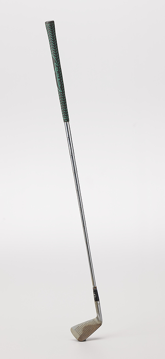 6 iron golf club used by Ethel Funches, late 20th century. Creator: Unknown. A 6 iron golf club, used by African American golfer Ethel Funches. The shaft is silver in color and is made out of metal. There is a black rubber grip at the top. The grip has short green diagonal lines going in both directions all around it. In the center there is a line drawing of an arrow like shape. There is text going vertically down both sides of the arrow. On the proper right side of the arrow it reads  GRIP RITE  and on the proper left side it reads  SWING RITE .