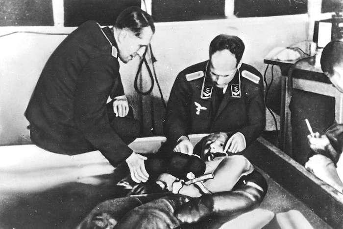 Cold water immersion during hypothermia experiments at Dachau concentration camp presided over by Professor Holzlohner (left) and Dr Rascher (right).  Prisoners did not volunteer, they were forced to participate.