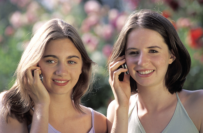 Mobile phone use MODEL RELEASED. Mobile phone use. Teenage girls on mobile phones.