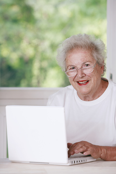 Laptop use MODEL RELEASED. Laptop use. Elderly woman using a laptop at home.