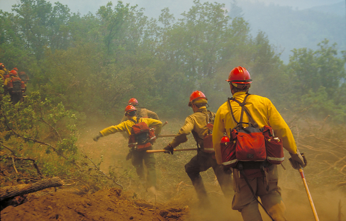 Firefighters Firefighters. Firefighters run to extinguish a spot fire at the perimeter of a forest fire. These firefighters are part of an elite crew of US firefighters known as  hotshots . They respond to fires rapidly and employ a variety of ground and air techniques to manage forest fires. On the ground, the firefighters carry hand tools such as shovels and pulaski axes to construct clear areas of land, known as a firebreak, in an attempt to halt the spread of the forest fire. Photographed in 2002 at Glenwood Springs, Colorado, USA.