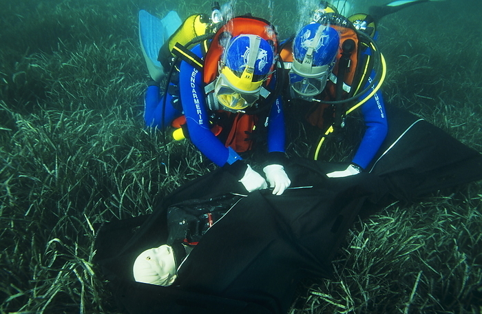 Dead body recovery training Dead body recovery. Police divers training in the recovery of a dead body from the seabed. As with any potential crime scene, great care must be taken to preserve, record and collect the evidence. A description or record of the crime scene is made, and a thorough search is made for evidence. The body itself is wrapped in a body bag, and key areas, such as the hands, are wrapped up separately to preserve evidence. Photographed in Antibes, France, as part of a training exercise by the French National Centre for Aquatic Police Training  CNING .