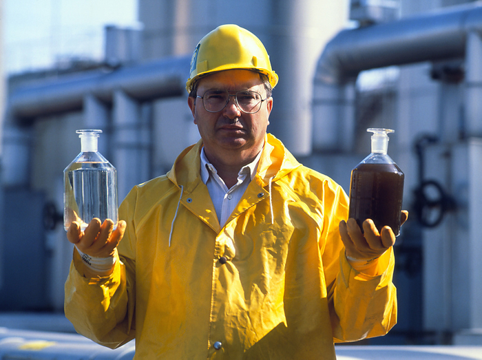 Worker holding treated an untreated sewage samples Sewage treatment. Worker holds samples of treated and untreated sewage. Sewage treatment involves using mechanical filtering and bacterial action to remove organic materials from water. The bacteria may then be filtered out before the water is discharged into a river or the sea.