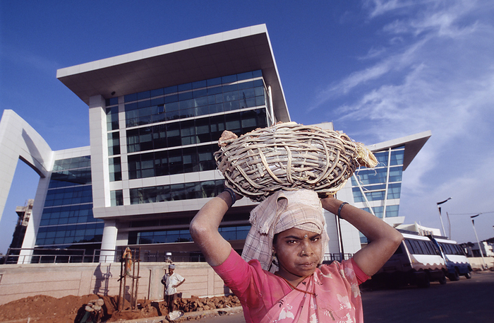 Construction worker Construction worker. Woman carrying building materials for the construction of new office buildings in Bangalore, India.