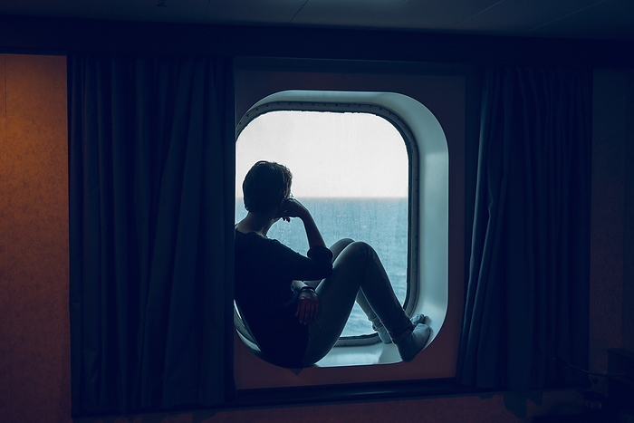 Frau blickt aus dem Fenster eines Schiffes, Bullauge Schiff, Mittelmeer, Italien Woman looking at view while sitting at ship window