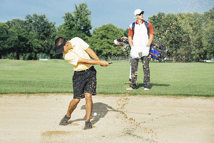 Golfer playing from bunker Golfer playing from bunker, action shot., Photo by MICROGEN IMAGES SCIENCE PHOTO LIBRARY