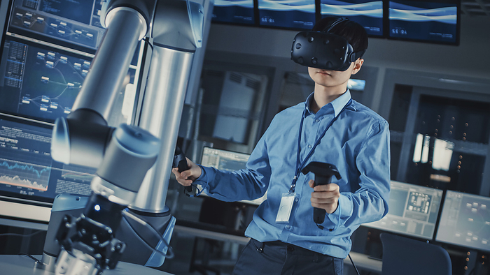 Engineer controlling a robotic arm using virtual reality Engineer controlling a robotic arm using virtual reality., Photo by GORODENKOFF PRODUCTIONS SCIENCE PHOTO LIBRARY
