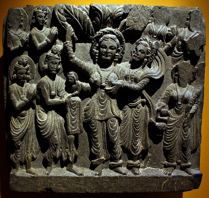 Birth of the Buddha.  Gandhara, about AD 200.  Schist.  Standing in a grove, Queen Maya gives birth to Prince Siddhartha Cautama, the future Buddha, from her right-side.  The infant is received by the god Indra, while other deities stand in attendance.