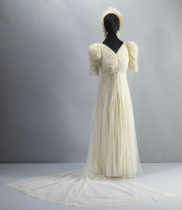 Wedding dress worn by Lollaretta Pemberton with veil and headpiece, 1939. Creator: Unknown. Lollaretta Elizabeth Pemberton  1895 1979  married Grover Joseph Allen  1889 1984  on 10 July  1939 in Marshall, Texas. She was Head of the Home Economics Department, Central High School, Marshall, USA. Wedding dress and accompanying accessories. The wedding gown is made of off white lace and tulle. The gown is floor length and has lace puffed sleeves to the elbows. There is ruching down the front of the front of the bodice. There is a matching long lace and tulle veil, with an attachable headpiece and faux floral headband.