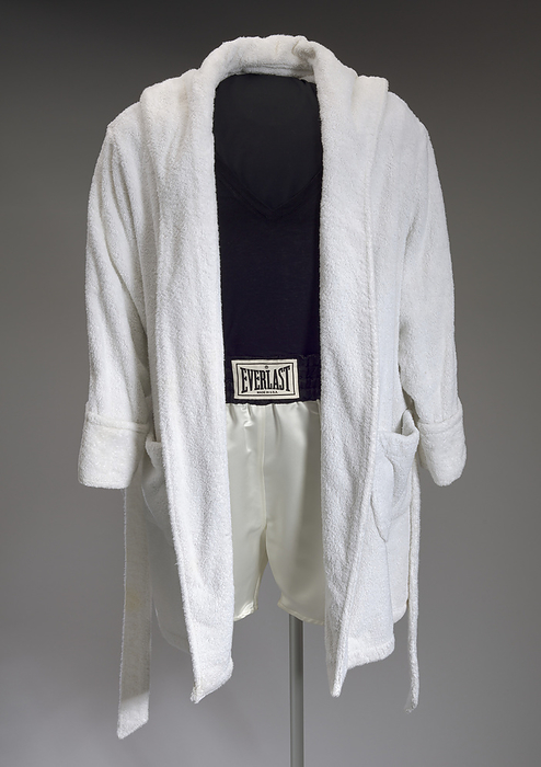 Robe and trunks worn by Denzel Washington as Rubin Carter in The Hurricane, 1999. Creator: Eric Winterling Inc.. A robe  .1ab  and a pair of boxing trunks  .2  worn by actor Denzel Washington as Rubin  Hurricane  Carter in the 1999 biopic,  quot The Hurricane quot , the story of an African American middleweight boxer who was wrongfully convicted of murder, eventually released   following a petition of habeas corpus   after serving almost 20 years in prison. The robe  .1a  is a long sleeved, knee length, hooded white terry cloth robe with a belt  .1b . The robe has a center opening with no fasteners. The sleeves end with thick trim that can be folded over to form cuffs. The belt is made of the same material as the robe, and is held in place by two  2  belt loops, one on the proper left side and one on the proper right side. There are two  2  patch pockets on the front of the robe, one on each hip. The custom made boxing trunks  .2  are cream satin with a 3 inch black satin waistband and 1 1 2 inch wide black satin vertical stripes on the proper left and proper right sides. The company label reading  EVERLAST  MADE IN U.S.A.  is sewn into the waistband at the center front. On the interior of the waistband at the center back is a manufacturer s label for the costume company  Eric Winterling, Inc.  New York  M . At the bottom of this label, the name  Mr. Washington  is typed onto the label. The trunks are not lined.