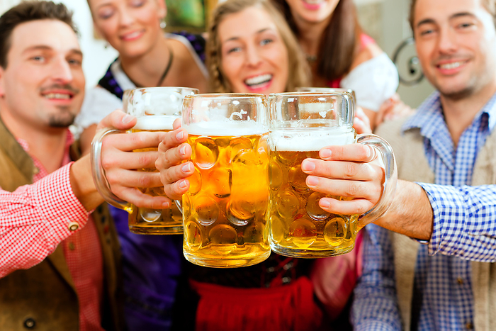 Woman   Fitness with Personal Trainer Inn or pub in Bavaria   group of five young men and women in traditional Tracht drinking beer and having a party with beer
