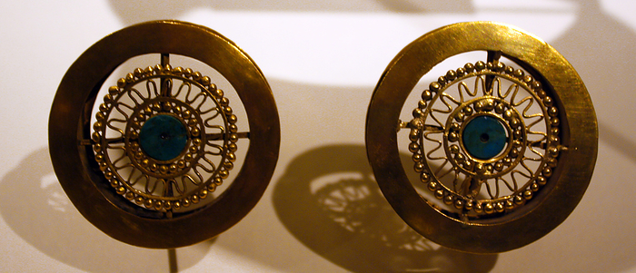 Pair of Earflares. Peru; Sican (Lambayeque) 9-11th century.  Hammered gold, turquoise inlay.  Archaeologists recently excavated a temple platform, where, almost forty feet below they found the tomb of a mighty Sican lord laid to rest with all the trappings of his power and wealth.