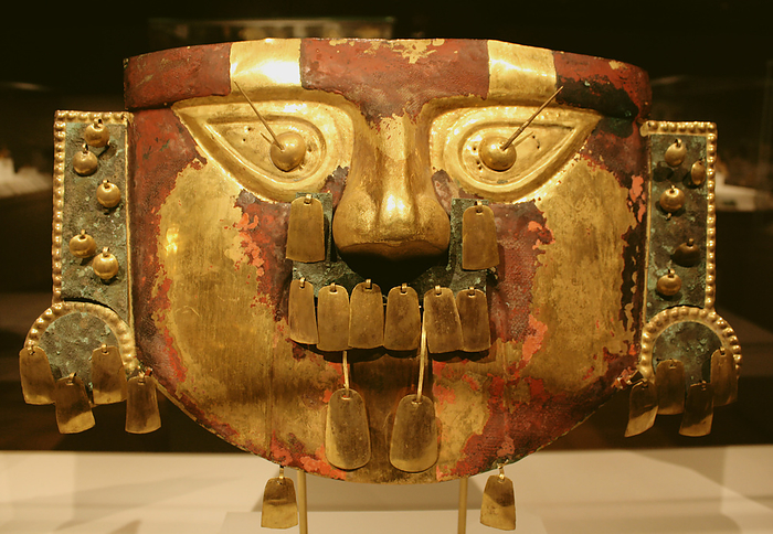 Funerary Mask.  Peru; Sican (Lambayeque) 9th-11th century.  Hammered gold, cinnabar, copper overlays.  The rich tombs of Sican rulers reportedly contained as many as five gold masks along with other precious offerings.