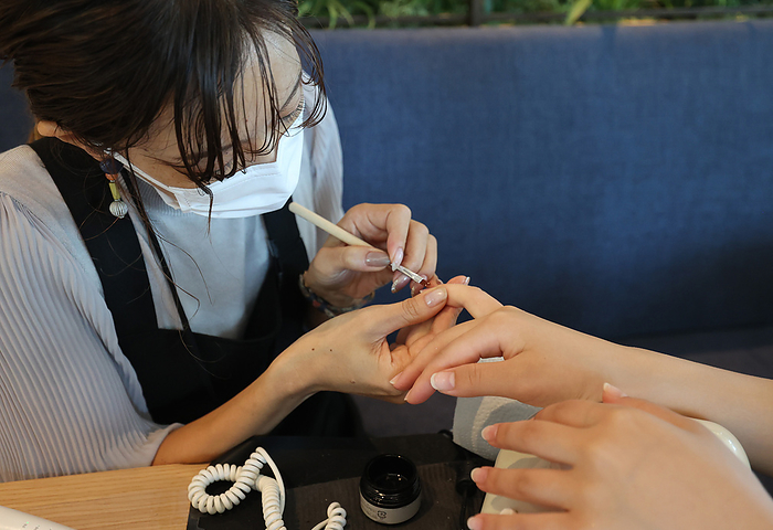 Completed  Tokiwa bashi Tower  in front of Tokyo Station July 19, 2021, Tokyo, Japan   A nail artist  L  polishes nails of an office worker for a demonstration at a relaxing floor of the new 38 story office building  Tokyo Torch Tokiwabashi Tower  at a press preview in Tokyo on Monday, July 19, 2021. Mitsubishi Estate has plan to build another tower in 2027 at the same complex which will become Japan s tallest building.     Photo by Yoshio Tsunoda AFLO  