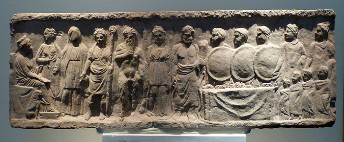 Votive relief, limestone, found at Livadia, Boeotia.  The relief is a dedication to the god=seer Trophonios, whose oracle was near Livadia.  Cybele is depicted at the left, seated on a throne, with a priestess in front of her, holding a key. The figure next to her is the initiate.  He is followed by Dionysus, Pan and Hekate holding two torches.  In the centre is Trophonios flanked by snakes. To his left are three Kouretes holding shields. The Dioskouroi are at the right edge with four worshippers. 350-325 BC