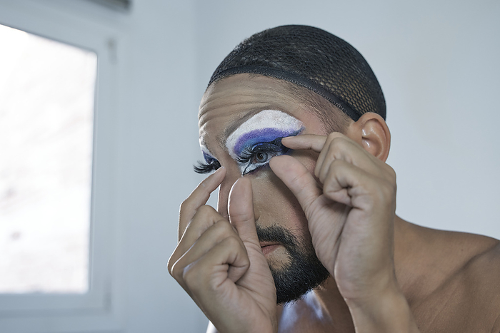 male Mid adult man applying eyelash at home