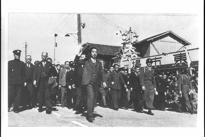 Emperor Hirohito  later Emperor Showa, center  on a nationwide tour. Emperor Hirohito  posthumous title: Showa Emperor  holds up his hat to a welcoming crowd gathered in front of a market in Ogaki City during his tour of the Chubu region of Japan. The Showa History of 100 Million People   5 , p. 151