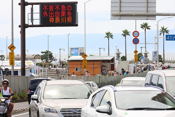 Katase Enoshima beach is crowded with bathers and beach parasols amid outbreak of the new coronavirus August 11, 2021, Fujisawa, Japan   An electric road sign displays  please refrain from unnecessary and unurgent outing  amid outbreak of the new coronavirus in Fujisawa, suburban Tokyo on Wednesday, August 11, 2021.     Photo by Yoshio Tsunoda AFLO 