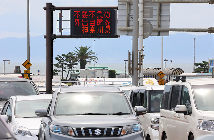 Katase Enoshima beach is crowded with bathers and beach parasols amid outbreak of the new coronavirus August 11, 2021, Fujisawa, Japan   An electric road sign displays  please refrain from unnecessary and unurgent outing  amid outbreak of the new coronavirus in Fujisawa, suburban Tokyo on Wednesday, August 11, 2021.     Photo by Yoshio Tsunoda AFLO 