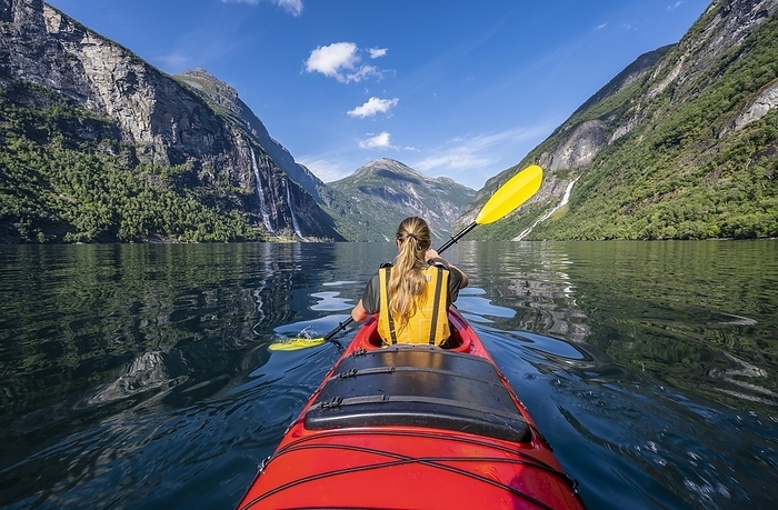 Young woman paddling in a kayak, Geirangerfjord, near Geiranger, Norway, Europe