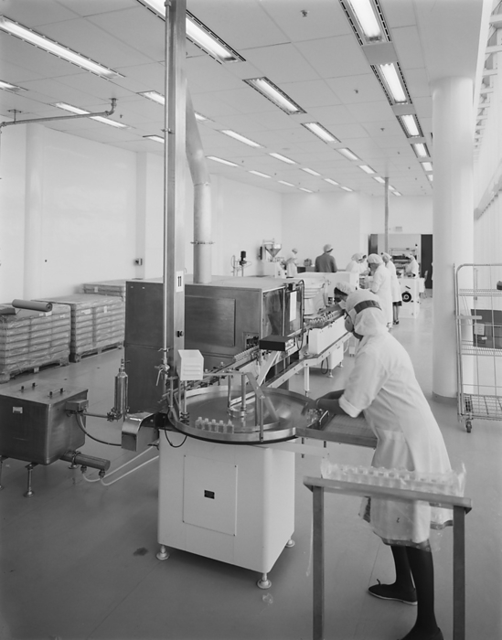 Napp Laboratories, Milton Road, Cambridge Science Park, Milton, Cambridgeshire, 06 09 1983. Creator: John Laing plc. A team of women working in the pesticides filling hall at Napp Laboratories. Napp Laboratories was built by Laing Management Contracting for Napp Pharmaceutical Group, with work starting in October 1980. The building project included a combined pharmaceutical production building and warehouse, research and laboratory services, administration offices, restaurant and auditorium. The building, which was designed by Toronto based Arthur Erickson Architects, consists of three buildings linked together to form one complex. Sitting 1200 mm above the surrounding land on a concrete podium, it also has an ornamental lake on the south side. It was constructed using 102 sloping precast concrete columns and solar reflective sloping double glazing known as structural glazing.