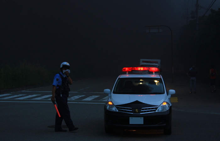 Police officers directing traffic at the scene of a fire at a plastic products warehouse.