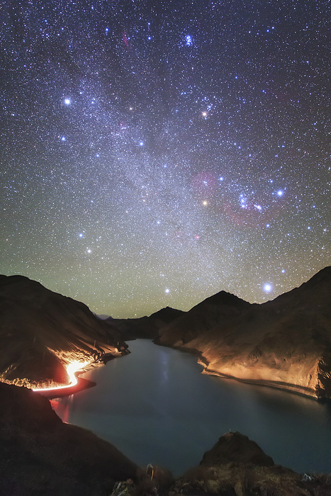 Winter Hexagon over Manla Reservoir Winter Hexagon over Manla Reservoir. Car headlights shining along the shores of Manla Reservoir, Tibet, China, with the Winter Hexagon rising in the night sky. The Winter Hexagon is a celestial asterism with vertices at the bright stars Rigel, Aldebaran, Capella, Pollux Castor, Procyon, and Sirius. Here, the band of our Milky Way Galaxy runs through the centre of the Winter Hexagon, while the Pleiades open star cluster and California Nebula are visible just above. Photographed on 12 November 2015.