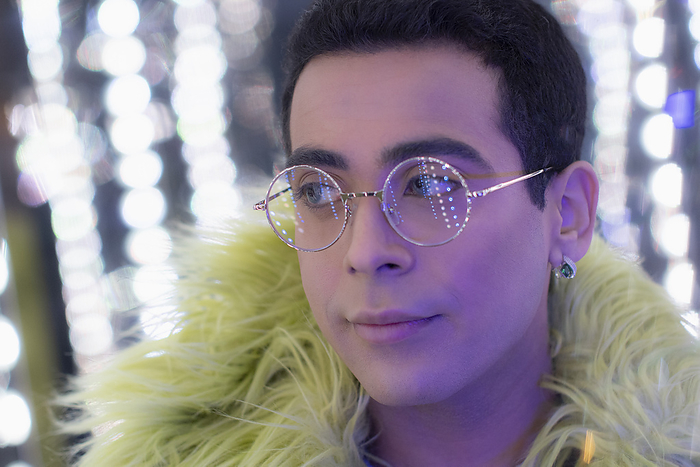 masculine gender Close up portrait young man in feather boa and eyeglasses