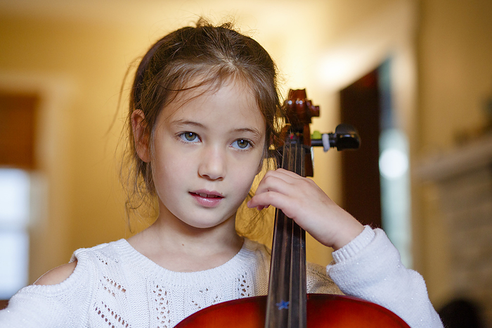 child close up of focused cute girl practicing cello at home,, Columbus, OH, United States