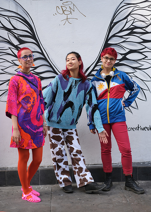 Spring Summer 2022 London Street Snapshot Street style shot on day one of London Fashion Week, season Spring Summer 2022, on Sunday September 19th 2021. Stylish guests and attendees arriving at or departing various live catwalk fashion shows. Image sows three young Chinese women visiting London from the north of England, and enjoying themselves in a colourful and playful manner