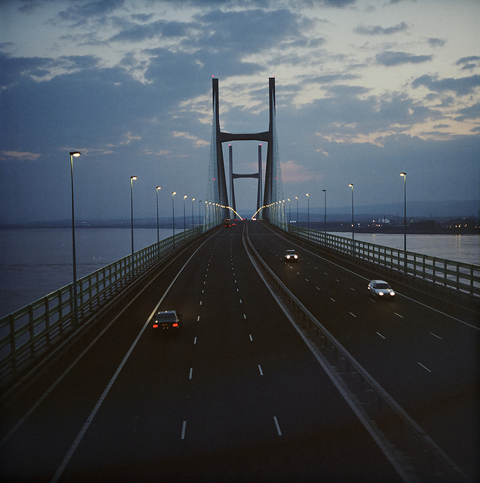 Second Severn Crossing, M4, New Passage, Pilning and Severn Beach, Gloucestershire, 03 06 1997. Creator: John Laing plc. A view of the Second Severn Crossing, looking along the deck of the bridge at night. The Second Severn Crossing took four years to build and was a joint civil engineering project between Laing Civil Engineering and the French company GTM. The work started in April 1992 and the opening ceremony later took place on 5th June 1996. The crossing is a cable stayed bridge which stretches over 5000 metres across the River Severn connecting England and Wales, 3 miles downstream from the Severn Bridge which opened in 1966.