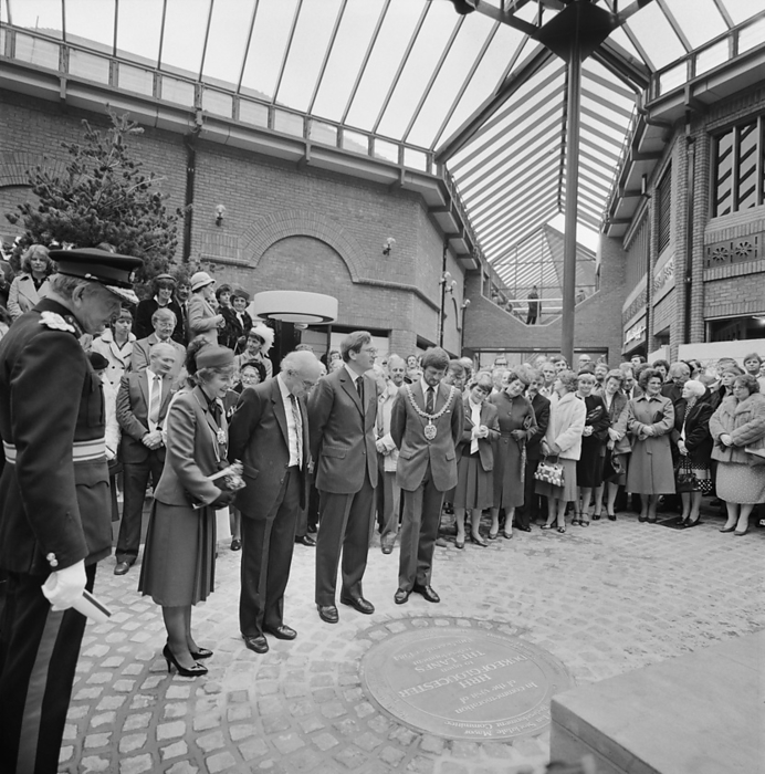 The Lanes Shopping Centre, Globe Lane, Carlisle, Cumbria, 19 11 1984. Creator: John Laing plc. HRH The Duke of Gloucester and the Mayor of Carlisle, councillor Ian Stockdale, with other dignitaries standing beside a plaque commemorating the official opening ceremony of The Lanes Shopping Centre. The contract for The Lanes Shopping Centre was awarded to John Laing Construction, Northern Division in October 1982 taking approximately two years to build. The H type configuration of the complex was built in reinforced concrete frames on pile caps and ground beams, with a large basement area at the lower end of the site. The complex included four major stores, 50 smaller shopping units, a three level county library, 27 housing units, offices and a multi storey car park. The shopping centre was officially opened on 19th November 1984 by HRH The Duke of Gloucester.