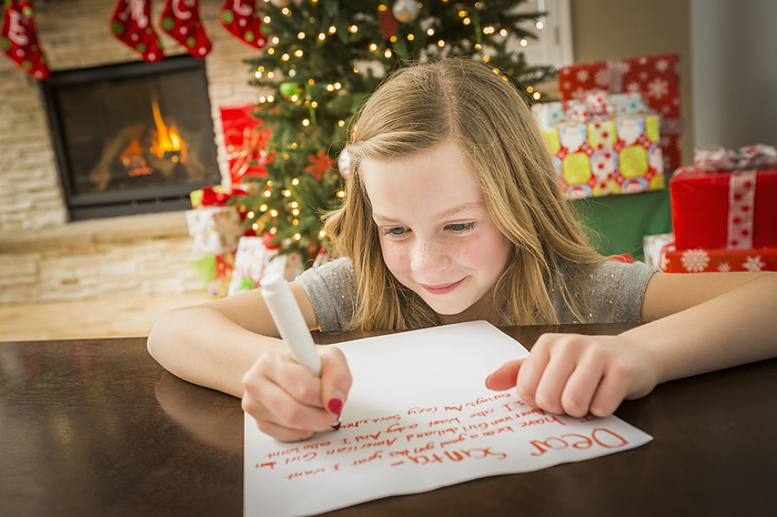 Child writing a letter to Santa Claus Caucasian girl writing to Santa at Christmas