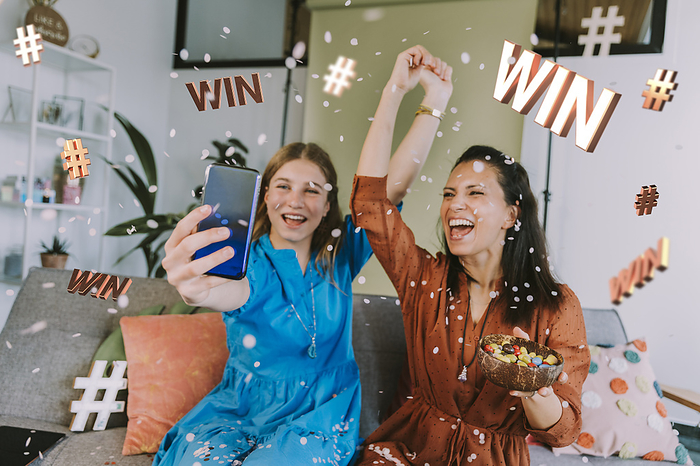 child Cheerful female influencers advertising sweepstakes through mobile phone at home