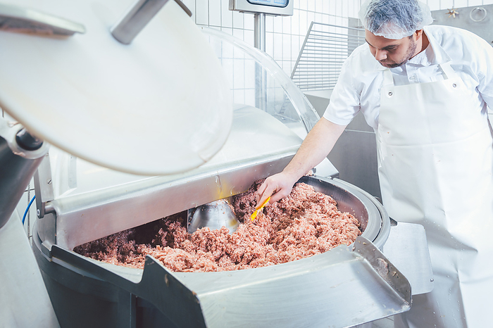 Butcher checking minced meat for the right quality Butcher checking minced meat for the right quality and consistency