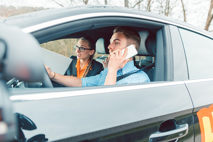 Driving instructor being mad at student using his telephone while driving Driving instructor being rather mad at student using his telephone while driving