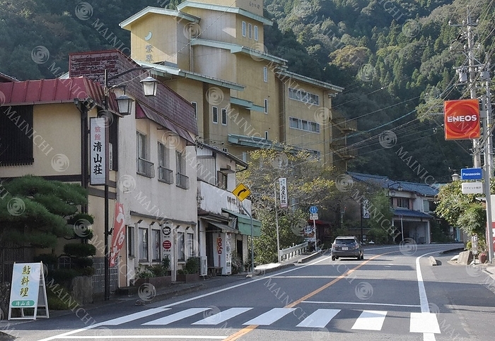 The abandoned Shisui kaku Tofu ya  back center  stands out in Sasado Onsen, a mountainous area lined with inns and stores. In Sasado Onsen, where inns and stores stand side by side in the mountains, the abandoned Shisui kaku Tofu ya  back center  stands out prominently. 2:21 p.m., October 9, 2021, in Toyota City, Aichi Prefecture  photo by Shiho Sakai.