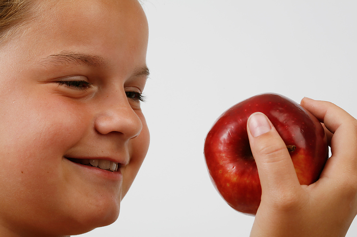 Young girl eating an apple Young girl eating an apple., Creditline:MEDICIMAGE   SCIENCE PHOTO LIBRARY