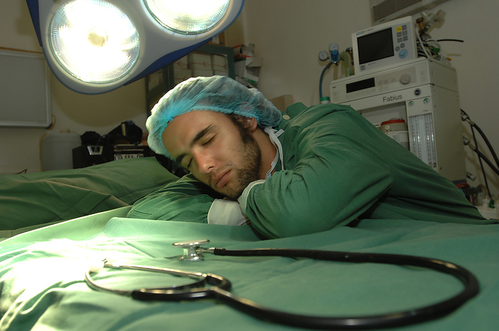 Young surgeon resting Young surgeon takes a well deserved rest., Creditline:MEDICIMAGE   SCIENCE PHOTO LIBRARY