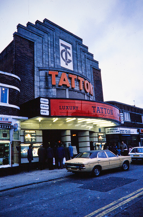 Tatton Cinema, Gatley Road, Gatley, Stockport, 1982 1995. Creator: Norman Walley. Tatton Cinema, Gatley Road, Gatley, Stockport, 1982 1995. The Tatton Cinema viewed from the south west at dusk, with people gathered below the projecting porch and billboard. The Tatton Kinema or Cinema opened in 1937. It seated approximately 1200 people in the stalls and circle, and also had a restaurant. It was divided into the Tatton Minor and Tatton Major Cinemas in 1971, and was again subdivided to create the Tatton Mini Cinema in 1976. It was renamed the Apollo Cinema after being bought by Apollo. The cinema closed in 2000 and the building was demolished, though the facade was retained.