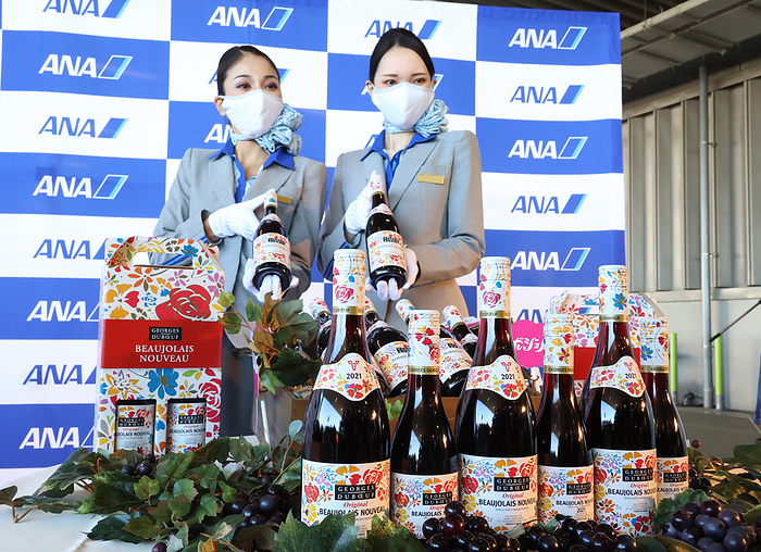 First shipment of 2021 Beaujolais Nouveau arrives at Haneda Airport October 23, 2021, Tokyo, Japan   All Nippon Airways  ANA  cabin attendants display bottles of 2021 vintage Beaujolais Nouveau after its arrival at the Haneda airport in Tokyo on Saturday, October 23, 2021. The first cargo of 3,192 bottles arrived from France  for November 18 when the embargo on the wine will be removed.      Photo by Yoshio Tsunoda AFLO  