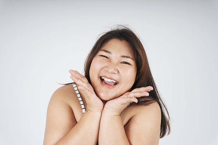 Close up of happy healthy asian chubby woman on white background.